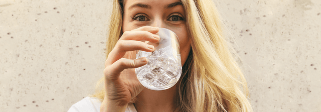 Frau trinkt bei Hitze Wasser