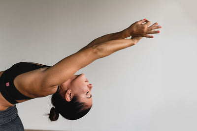 Frau macht Yoga und kombiniert Fasten und Sport.